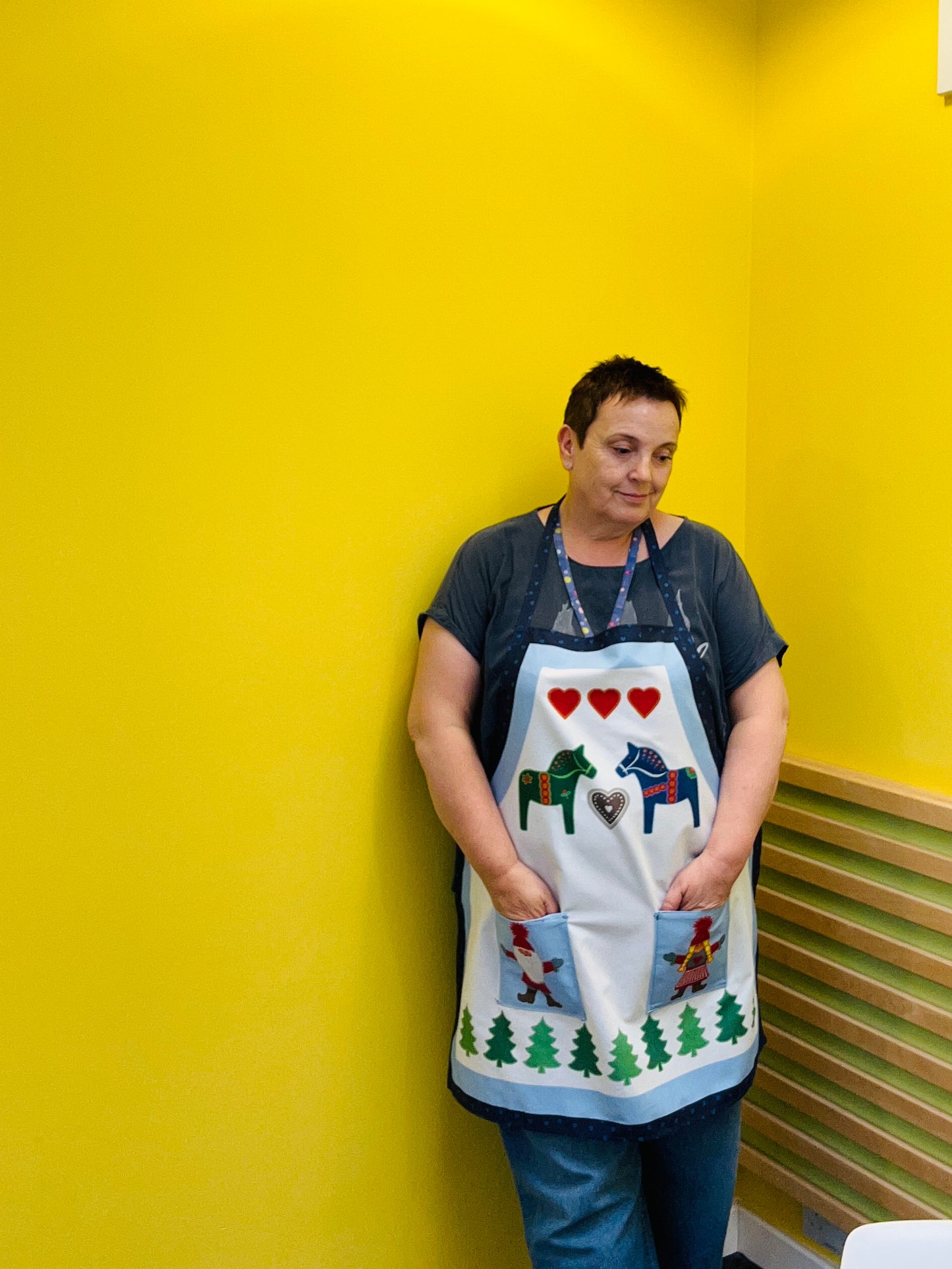 Person wearing a decorative apron against a yellow wall